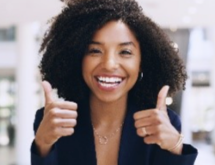 Woman smiling and giving two thumbs up